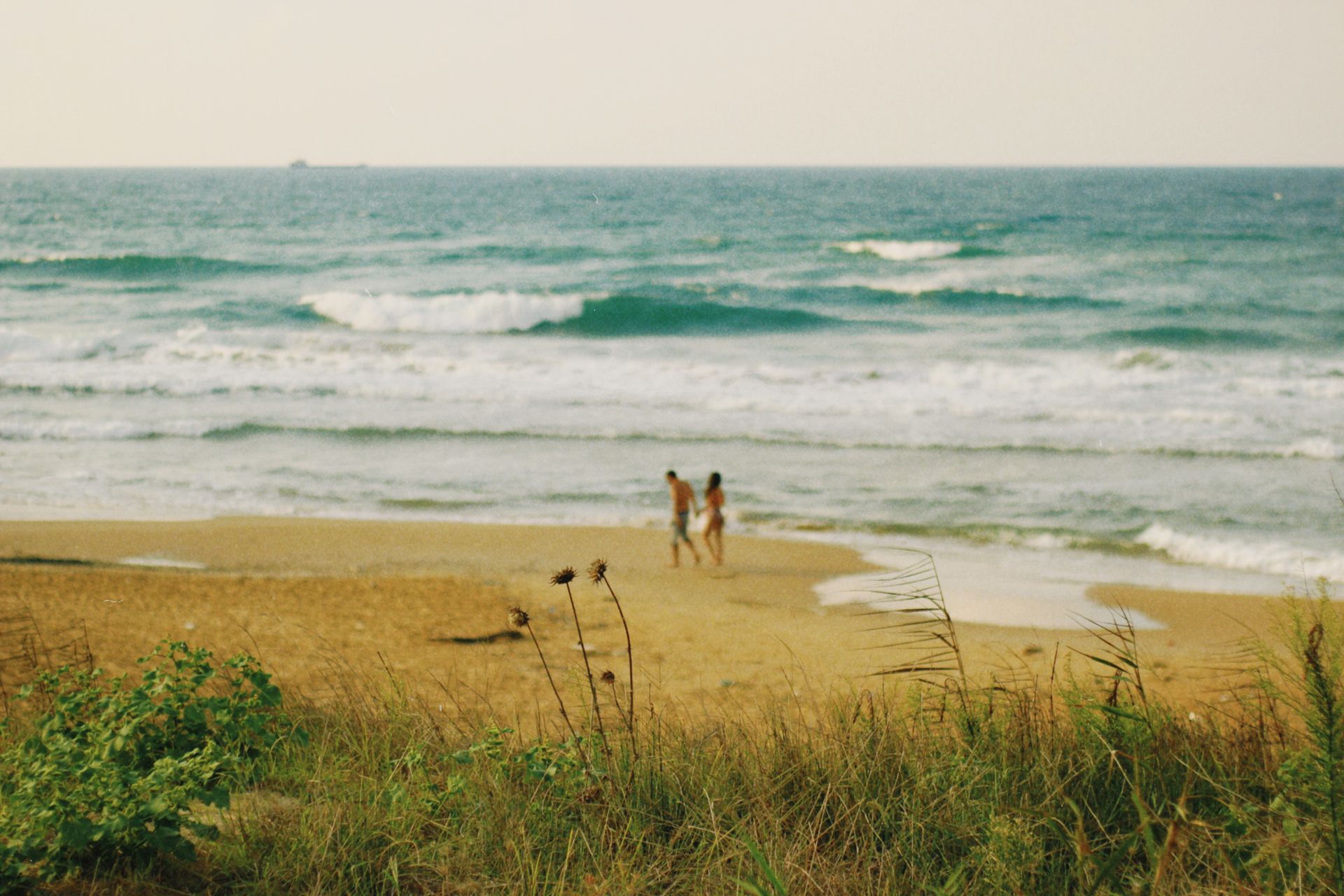 Due ragazzi camminano lunga la spiaggia